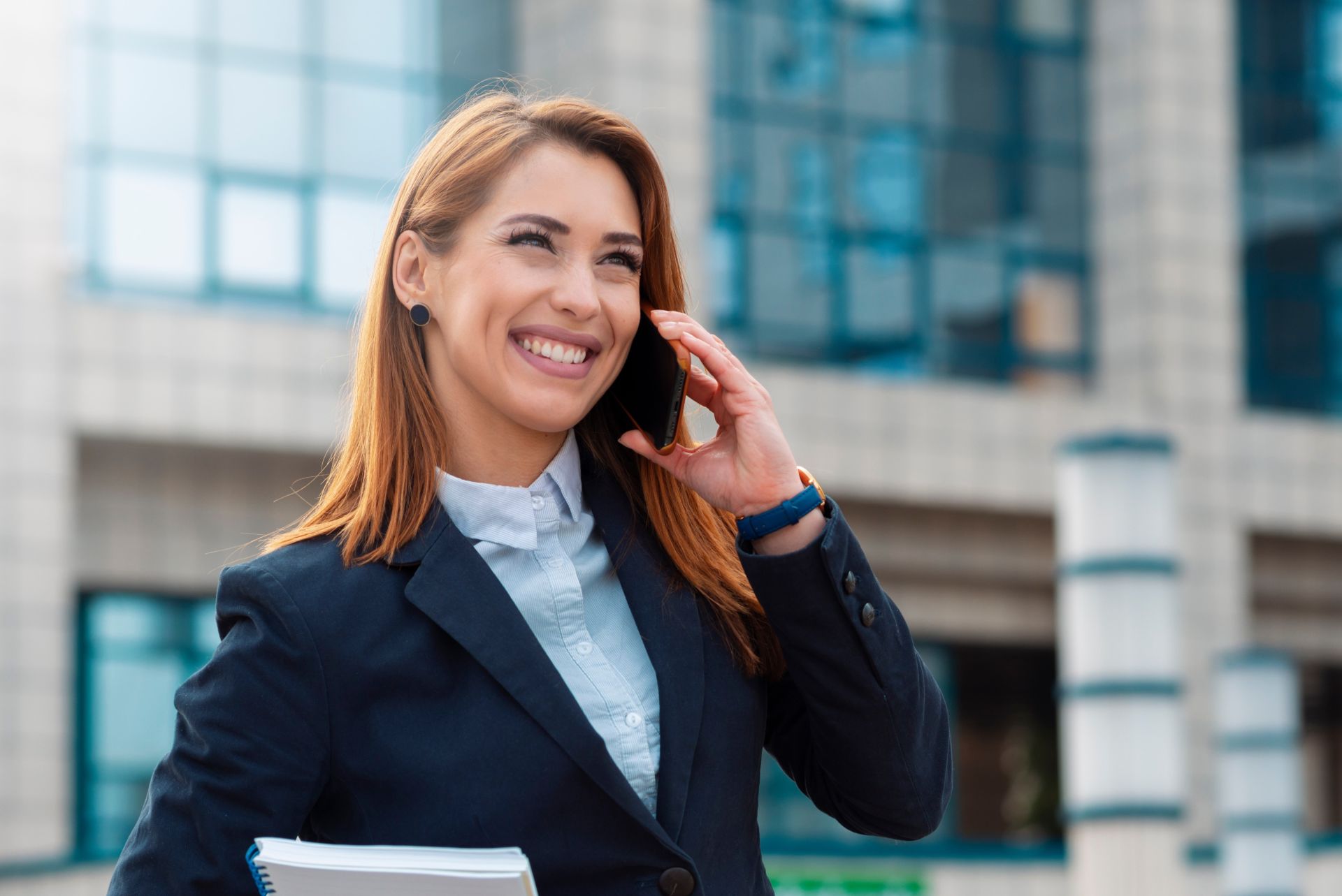 Two businesswomen enjoy a coffee break and conversation in a modern office setting.